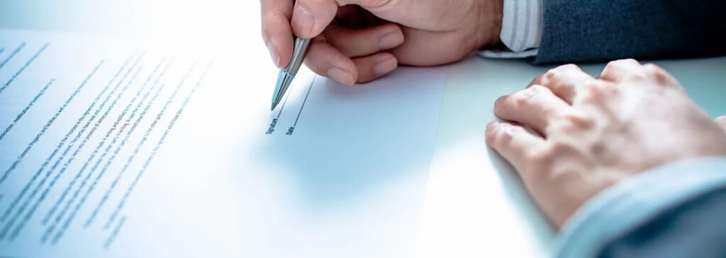 Hand drawing two parallel lines with a pen on paper.